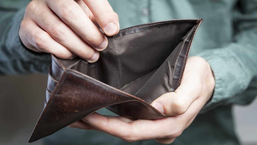 Homem com uma carteira vazia aberta, mostrando sobre os 6 erros financeiros que você deve evitar.