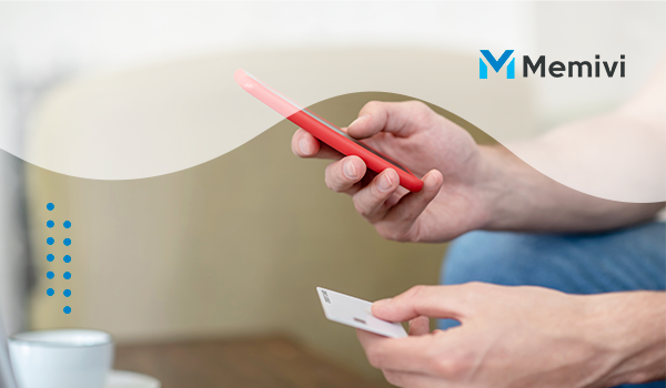 Como ler a fatura do seu cartão? mãos segurando um smartphone vermelho 